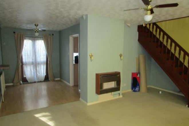 empty living room with gas fireplace and fan