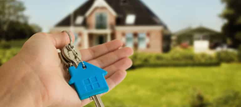 house keys with house in background