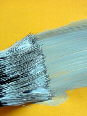 blue paint brush on yellow wall