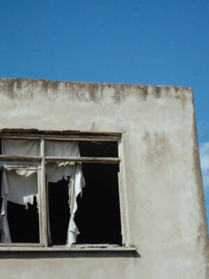 blue ski, broken window, old concrete building